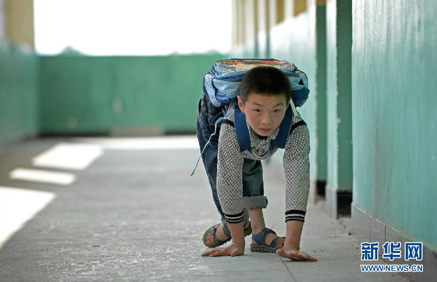 Cậu bé Lạc Điền Sâm ở Nhâm Điền, Thụy Kim, tỉnh Giang Tây, Trung Quốc hằng ngày phải bò đến lớp vì căn bệnh bại liệt. (Nguồn: xinhua)