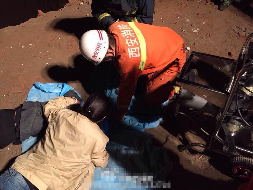 Ba giờ sáng, trời đổ mưa nên người dân phải lấy vải dù để che miệng giếng. (Nguồn: QQ)