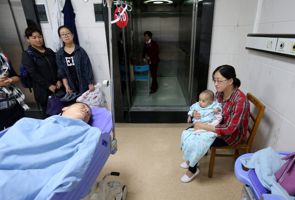 Tám tháng trước, người cha đã mang lại sinh mệnh cho cô con gái và 8 tháng sau, cũng chính người cha đó đã dùng lá gan của cơ thể mình để duy trì sự sống cho cô con gái bé bỏng. Người cha 8X đó là Hoàng Xuyên, người Phúc Châu, Trung Quốc. Bức ảnh này ghi lại cảnh Hoàng Xuyên chuẩn bị vào phòng phẫu thuật, anh an ủi vợ: 'Đừng lo lắng, anh chỉ ngủ một giấc thôi mà.' (Nguồn: QQ)