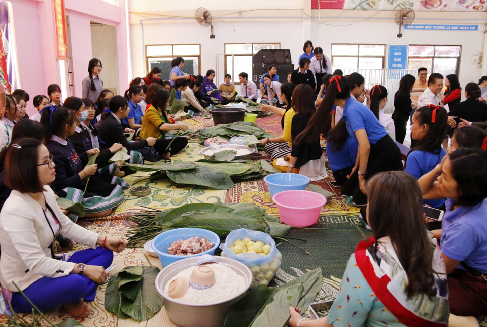 Hoạt động gói bánh chưng ngày Tết của Trường song ngữ Lào-Việt Nam Nguyễn Du. (Ảnh: Phạm Kiên/Vietnam+)