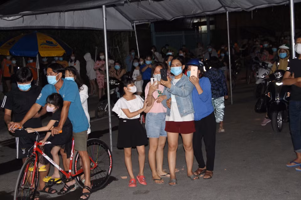 Người dân, sinh viên sống khu vực phong tỏa phường Phú Hòa, thành phố Thủ Dầu Một, tỉnh Bình Dương sau khi được dỡ bỏ phong tỏa. (Ảnh: Chí Tưởng/TTXVN)
