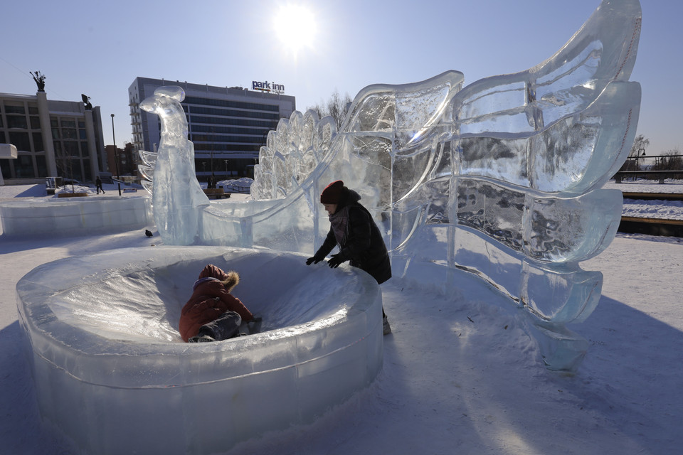 Trẻ em thích thú vui chơi cùng những tác phẩm điêu khắc băng. (Ảnh: Duy Trinh/TTXVN)