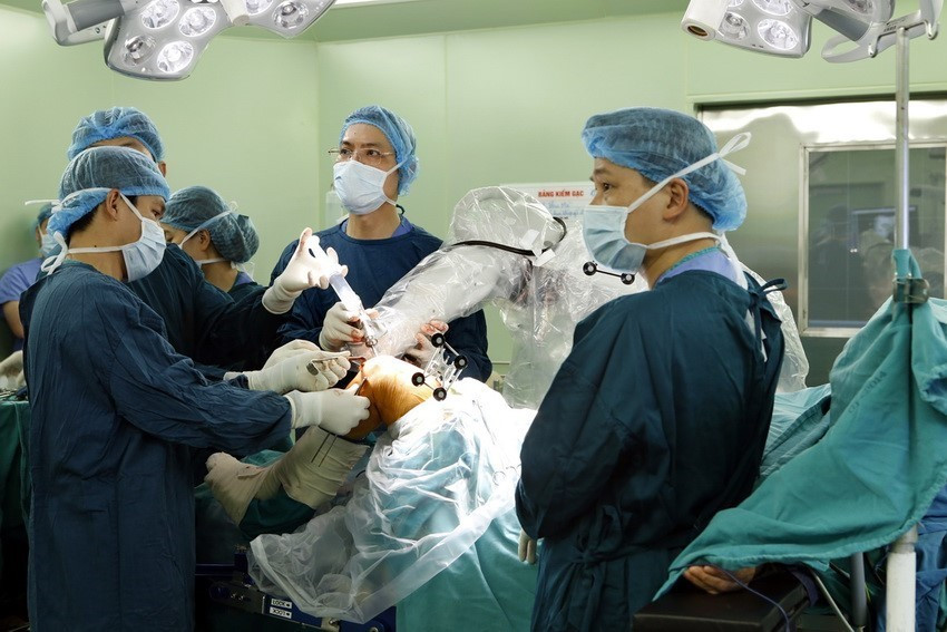 Nhiều kỹ thuật chuyên môn cao được thực hiện thành công tại nhiều bệnh viện trung ương như ghép tạng, nội soi, phẫu thuật bằng robot, chuyển giao một số kỹ thuật cho bệnh viện tuyến tỉnh, huyện...Trong ảnh: Một ca phẫu thuật khớp gối sử dụng robot tại bệnh viện Bạch Mai. (Ảnh: Dương Ngọc/TTXVN)