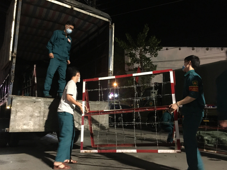 Lực lượng chức năng thành phố Thủ Dầu Một, tỉnh Bình Dương tháo gỡ điểm phong tỏa khu vực phường Phú Hòa và Trường Đại học Thủ Dầu Một. (Ảnh: Chí Tưởng/TTXVN)