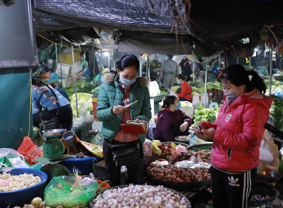 Tiểu thương kinh doanh tại chợ và người dân thực hiện nghiêm việc đeo khẩu trang phòng chống dịch bệnh. (Ảnh: Vũ Sinh/TTXVN)
