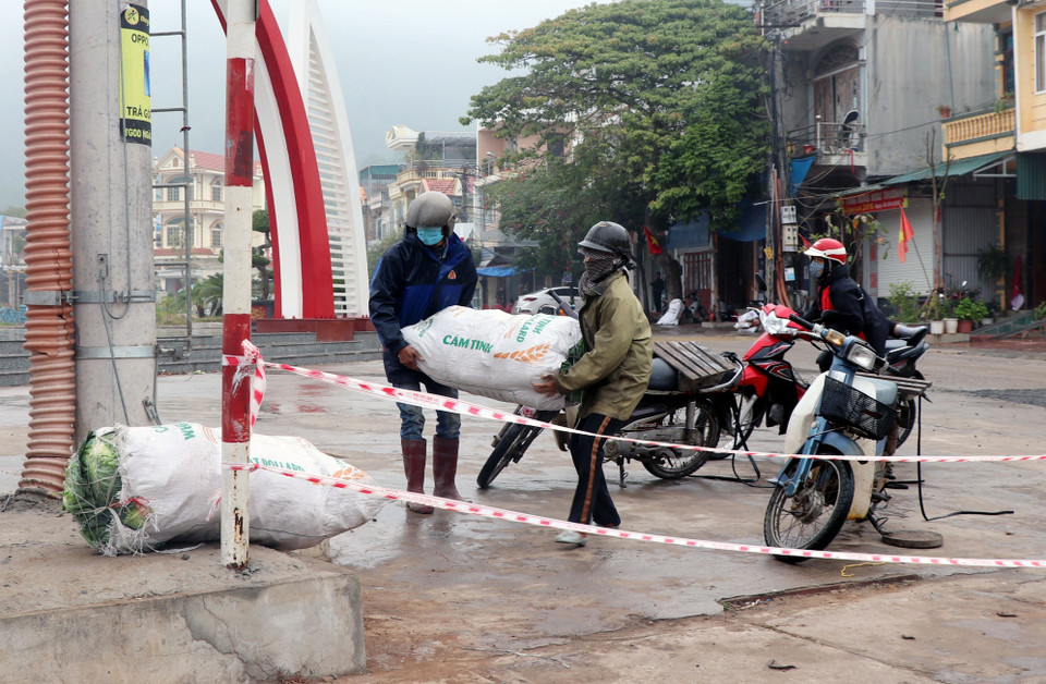 Người dân mang nhu yếu phẩm đến chốt kiểm dịch để cung cấp cho người thân trong vùng phong tỏa. (Ảnh: Văn Đức/TTXVN)