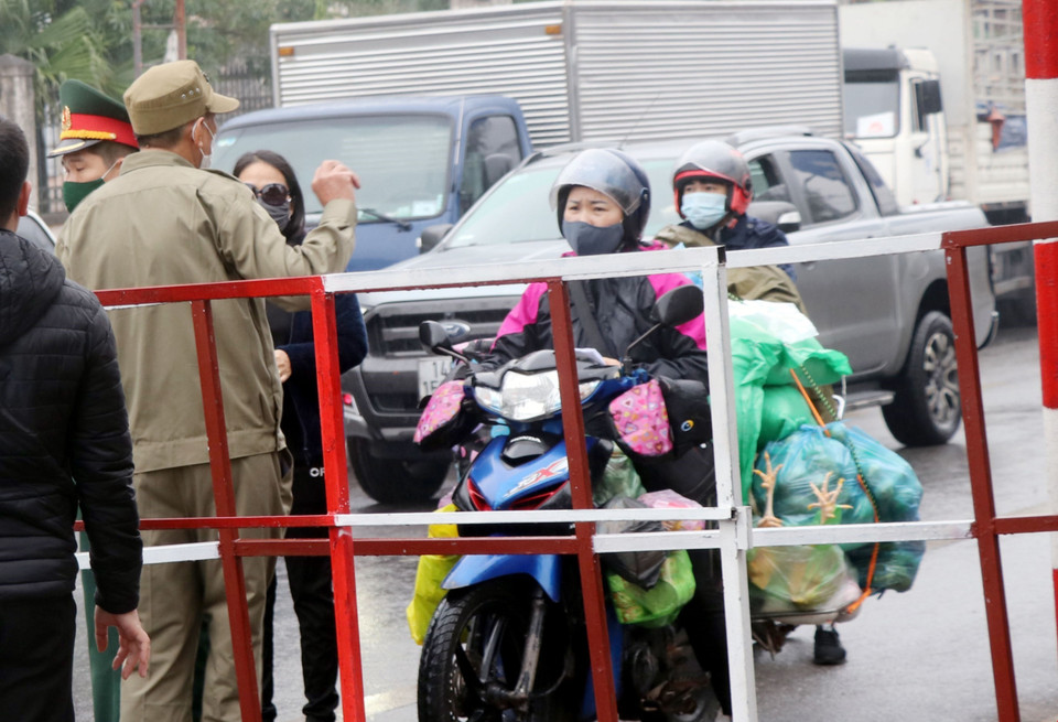 Người dân mang nhu yếu phẩm đến chốt kiểm dịch để cung cấp cho người thân trong vùng phong tỏa. (Ảnh: Văn Đức/TTXVN)