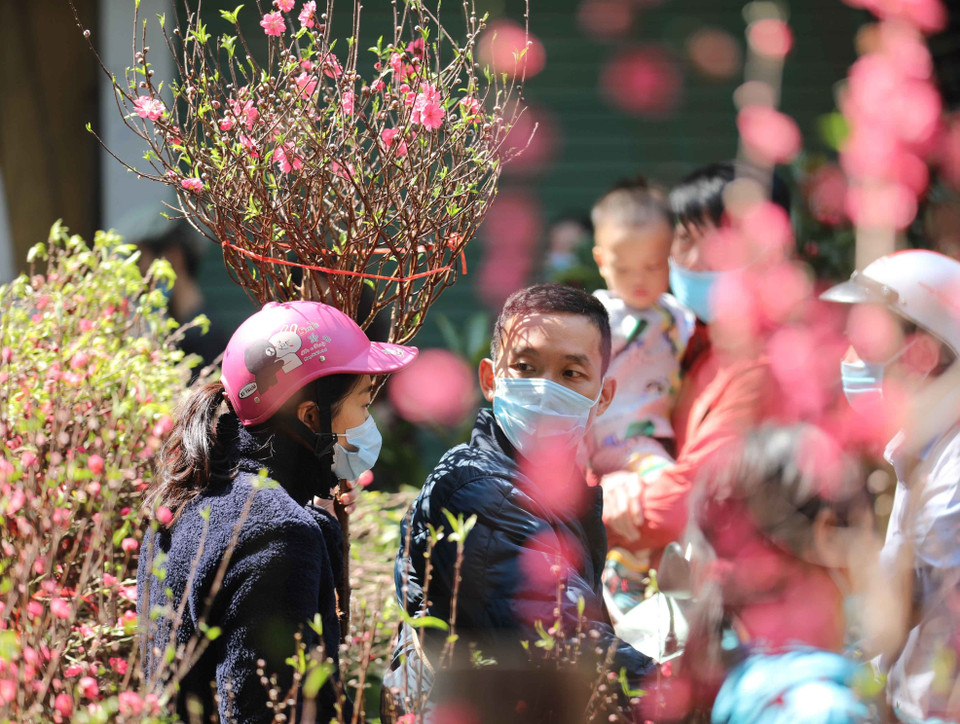 Người dân đi chợ hoa Tết truyền thống thực hiện nghiêm túc việc đeo khẩu trang để phòng chống dịch. (Ảnh: Thanh Tùng/TTXVN)