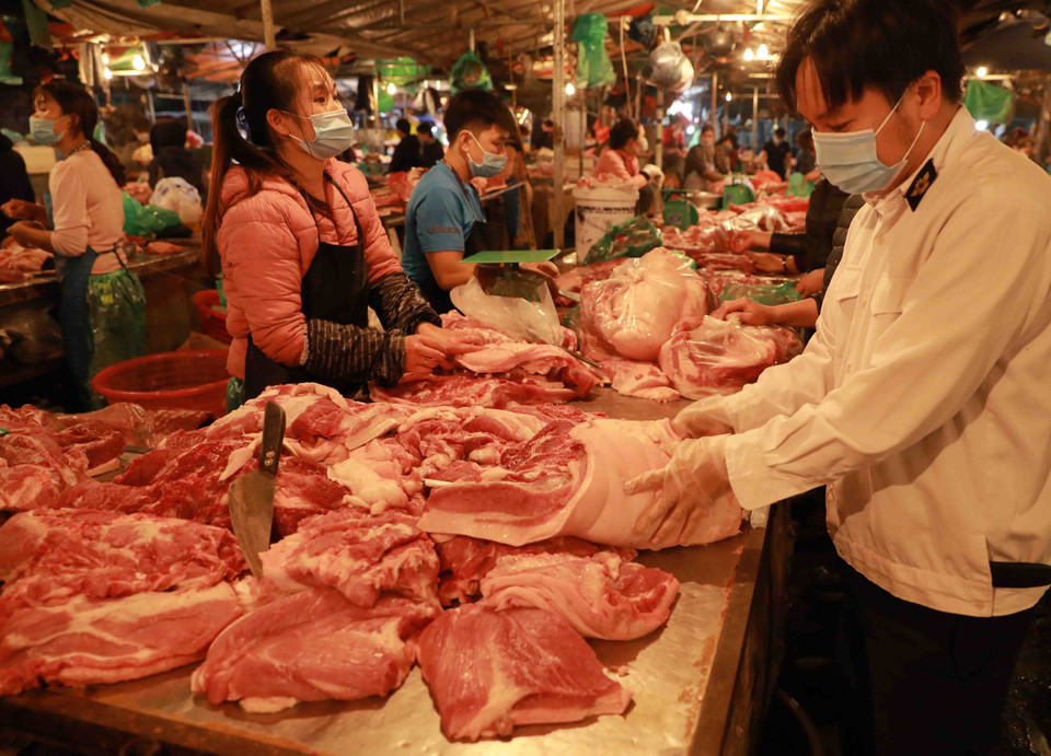 Nhân viên Thú y kiểm tra an toàn vệ sinh thực phẩm tại một quầy bán thịt lợn ở chợ Nam Hà Nội. (Ảnh: Vũ Sinh/TTXVN)