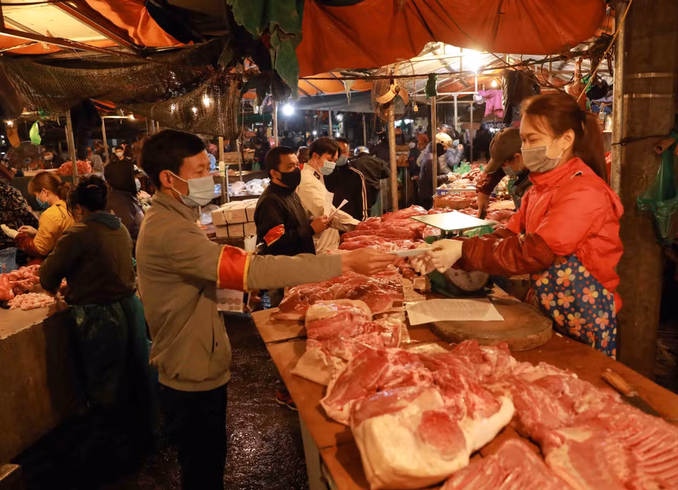 Nhân viên Ban Quản lý chợ phát khẩu trang y tế và tuyên truyền cho tiểu thương, người dân đến mua sắm nâng cao ý thức trong công tác phòng chống dịch bệnh. (Ảnh: Vũ Sinh/TTXVN)