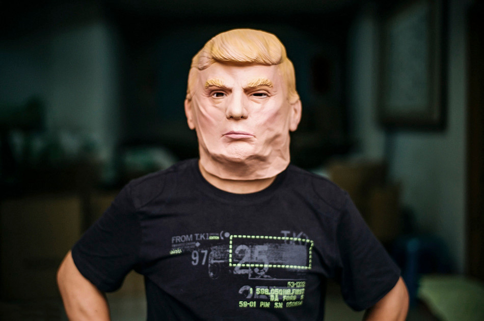Một công nhân trải nghiệm cảm giác khi đeo chiếc mặt nạ Donald Trump ở Thâm Quyến, Quảng Đông. (Nguồn: The Paper)