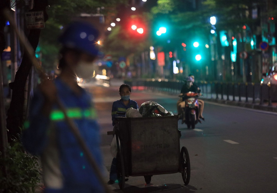 Các công nhân vệ sinh tổ 13 (Công ty TNHH Một thành viên Môi trường đô thị Hà Nội ) thu gom, vận chuyển chất thải sinh hoạt về các khu xử lý tập trung của thành phố. (Ảnh: Tuấn Anh/TTXVN)