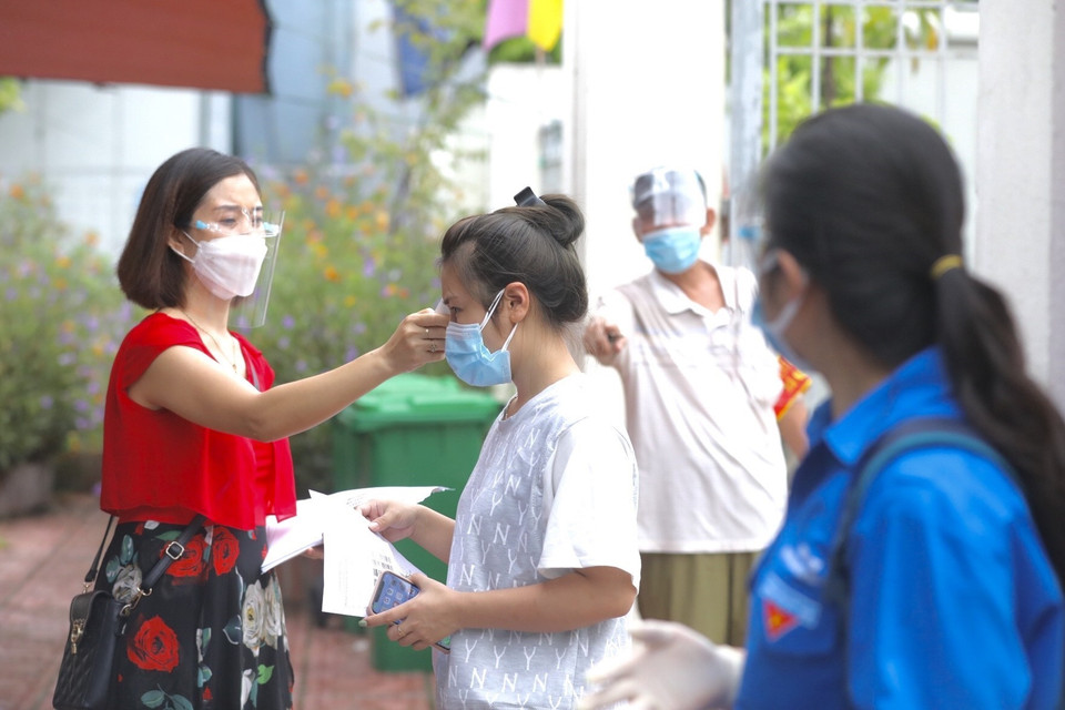 Người dân đến lấy mẫu được kiểm tra thân nhiệt và khai báo y tế (ảnh chụp ngày 10/8/2021). (Ảnh: Minh Quyết/TTXVN)