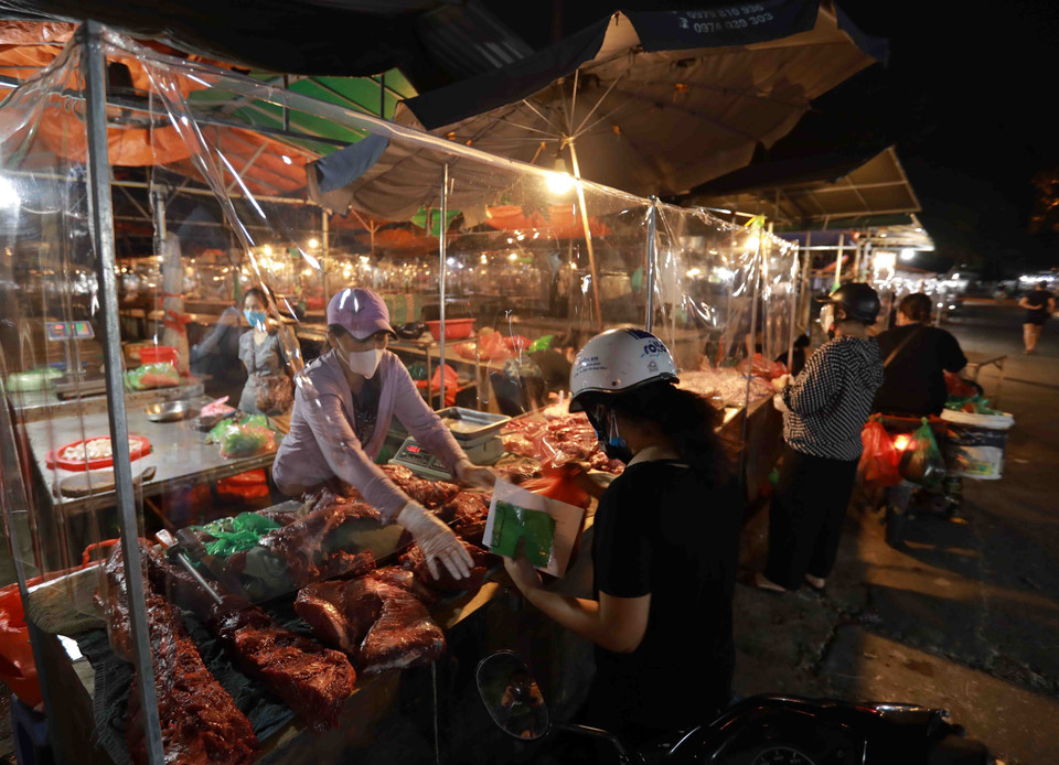 Các hoạt động mua, bán đều phải đảm bảo giữ khoảng cách an toàn và có tấm kính chắn giữa người bán, người mua. (Ảnh: Vũ Sinh/TTXVN)