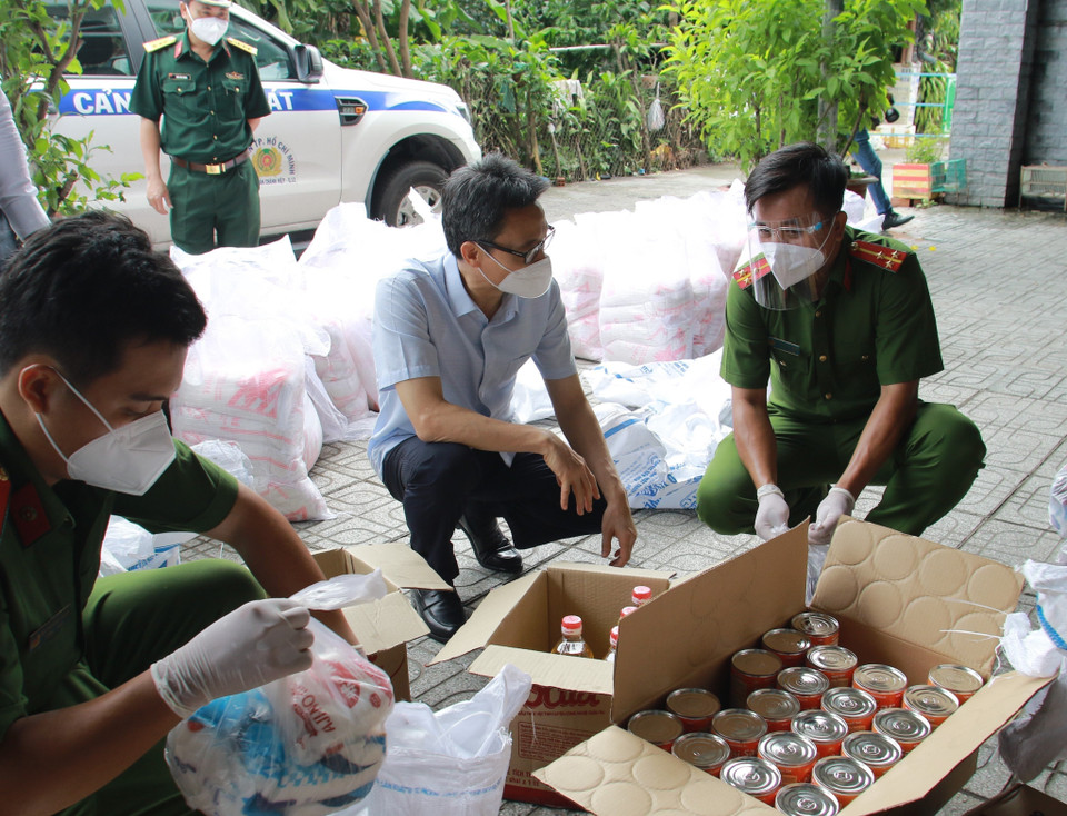 Phó Thủ tướng Vũ Đức Đam động viên lực lượng công an đang làm nhiệm vụ hỗ trợ người dân tại khu phong tỏa cách ly phường Tân Chánh Hiệp, quận 12. (Ảnh: Xuân Tình/TTXVN)