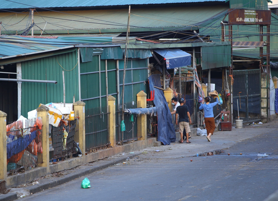 Một số người trong khu vực phong tỏa chợ Long Biên vẫn tìm cách chui ra ngoài. (Ảnh: Hoàng Hiếu/TTXVN)