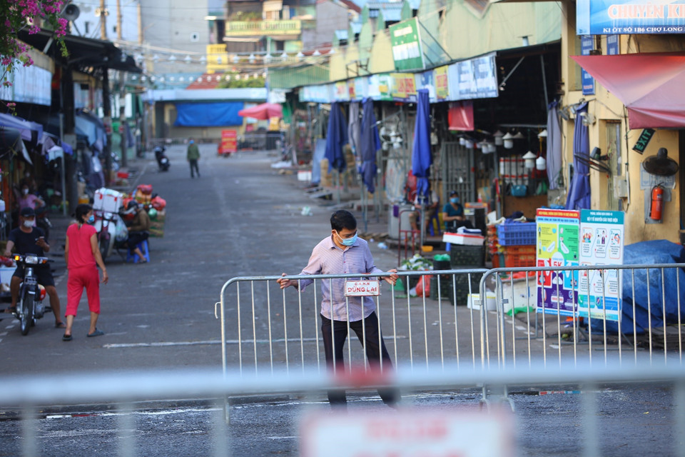 Lực lượng chức năng lập rào chắn phong tỏa chợ Long Biên. (Ảnh: Hoàng Hiếu/TTXVN)