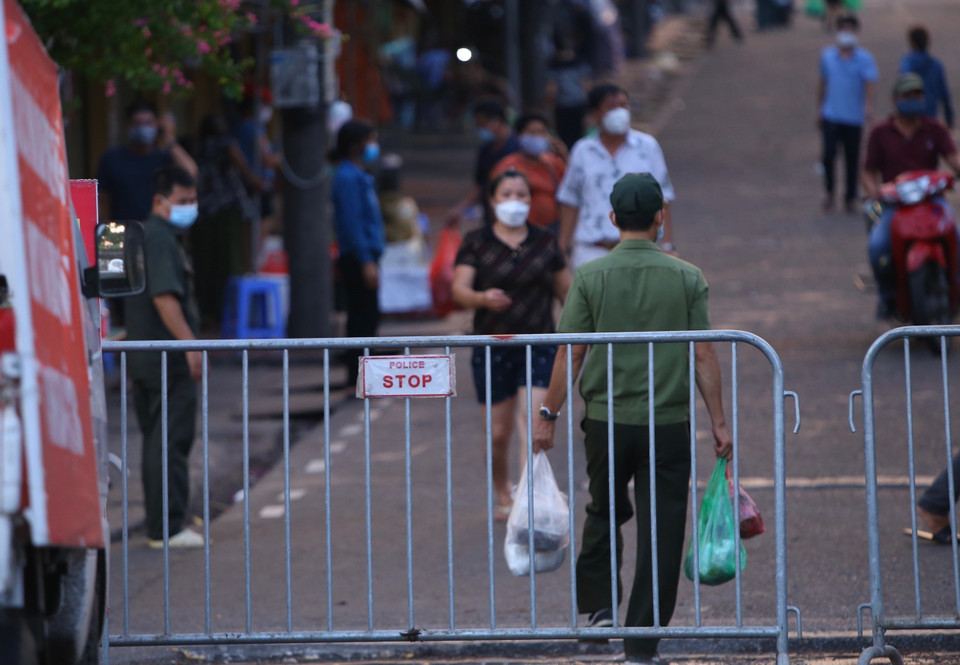 Chuyển đồ tiếp tế cho người dân trong chợ Long Biên bị phong tỏa tạm thời. (Ảnh: Hoàng Hiếu/TTXVN)