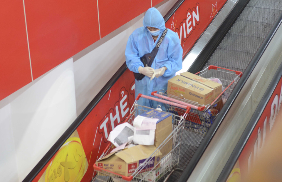 Đội ngũ shipper được phép giao hàng trong thời gian từ 6 giờ đến 20 giờ, đồng thời phải đủ các điều kiện như được tiêm vaccine phòng COVID-19 ít nhất 1 lần, xét nghiệm SARS-CoV-2 định kỳ 3 ngày/lần, trong quá trình giao hàng phải mặc áo quần bảo hộ, gang tay, kính chắn giọt bắn, thực hiện đúng thông điệp 5K của Bộ Y tế, có thẻ nhận diện tham gia giao thông kèm giấy tờ tùy thân. Một shipper đến lấy hàng tại siêu thị Big C. (Ảnh: Văn Dũng/TTXVN)