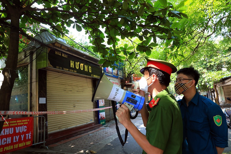 Công an phường Thanh Xuân Bắc gọi loa, nhắc nhở người dân thực hiện công tác phòng, chống dịch trong khu vực cách ly. (Ảnh: Tuấn Anh/TTXVN)