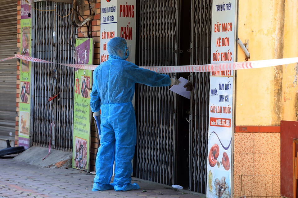 Thông báo Quyết định cách ly y tế của Ủy ban Nhân dân quận Thanh Xuân được đưa đến từng hộ dân. (Ảnh: Tuấn Anh/TTXVN)