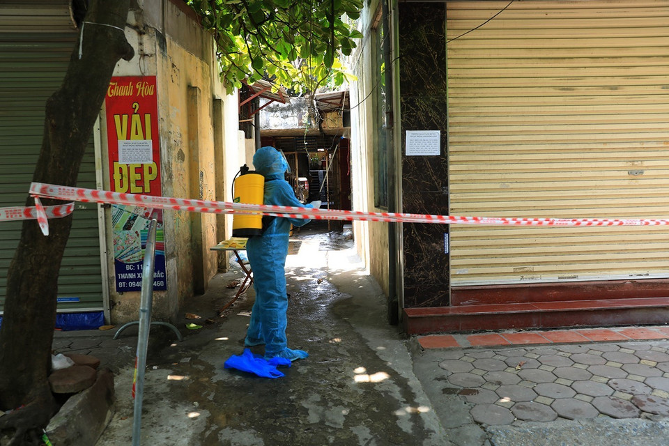 Lực lượng y tế tổ chức phun khử khuẩn khu vực phong tỏa, cách ly y tế. (Ảnh: Tuấn Anh/TTXVN)