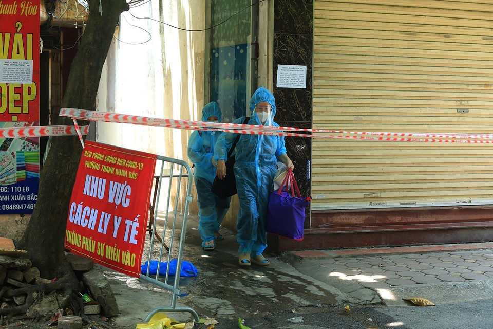 Các trường hợp F1 tại nhà E8 được đưa đi cách ly. (Ảnh: Tuấn Anh/TTXVN)