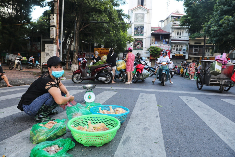 Từ sáng sớm 16/8, hàng chục tiểu thương cùng người đi chợ tràn xuống lòng đường khu vực bốt Hàng Đậu, bất chấp quy định phòng chống dịch (Ảnh chụp lúc 6h sáng). (Ảnh: Thành Đạt/TTXVN)