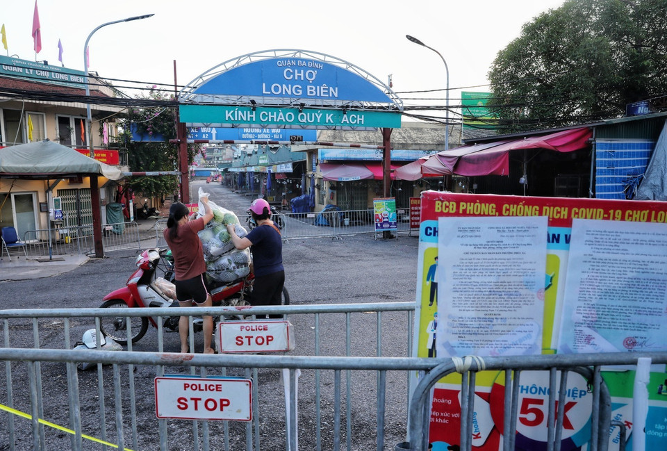 Chợ Long Biên đang bị phong tỏa để phòng dịch COVID-19, người dân không có nơi họp chợ nên đã họp chợ ngay dưới lòng đường. (Ảnh: Thành Đạt/TTXVN)