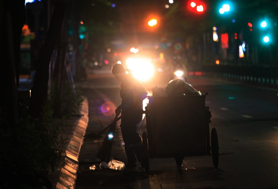 Công nhân Công ty TNHH Một thành viên Môi trường đô thị Hà Nội quét dọn, thu gom, vận chuyển chất thải trên phố Nguyễn Lương Bằng. (Ảnh: Tuấn Anh/TTXVN)