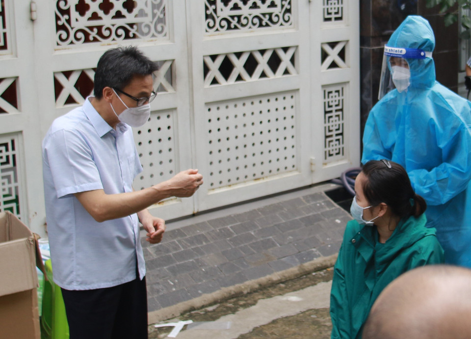 Phó Thủ tướng Vũ Đức Đam hướng dẫn người dân tự lấy mẫu xét nghiệm để hạn chế lây nhiễm chéo tại khu phong tỏa cách ly phường Tân Chánh Hiệp, quận 12. (Ảnh: Xuân Tình/TTXVN)