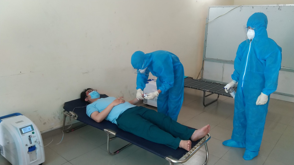 Các chiến sỹ thăm khám và điều trị cho F0 trên địa bàn phường 6. (Ảnh: Mạnh Linh/TTXVN)