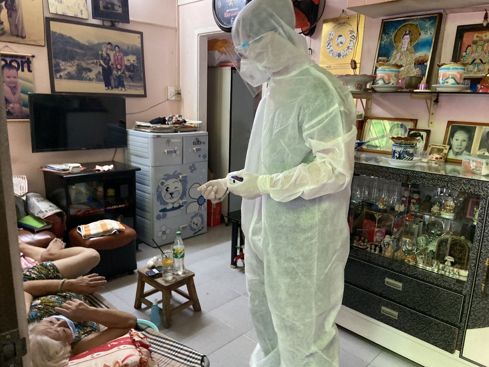 Lực lượng Quân y thăm khám cho một cụ bà F0 ở Khu phố 1, phường 6. (Ảnh: Mạnh Linh/TTXVN)