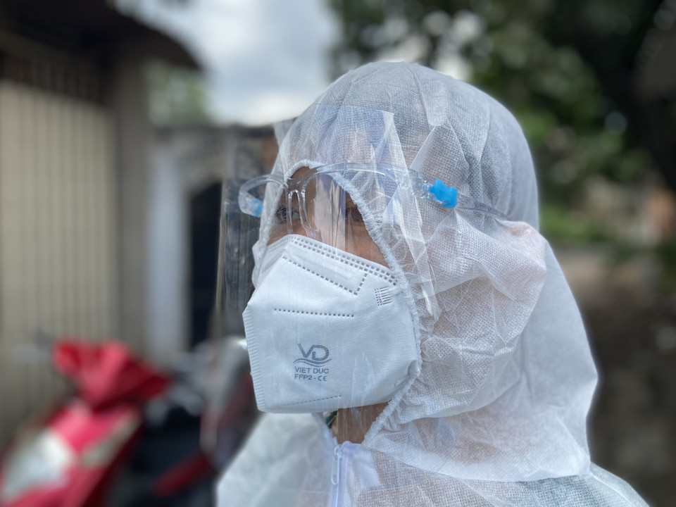 Lực lượng Quân Y trong bộ đồ bảo hộ kín mít đến nhà dân để khám, chữa bệnh cho các F0. (Ảnh: Mạnh Linh/TTXVN)