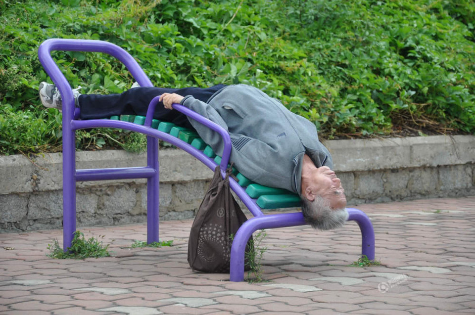 Cụ già ngủ ngay trên một dụng cụ thể dục ngoài đường. (Nguồn: QQ)