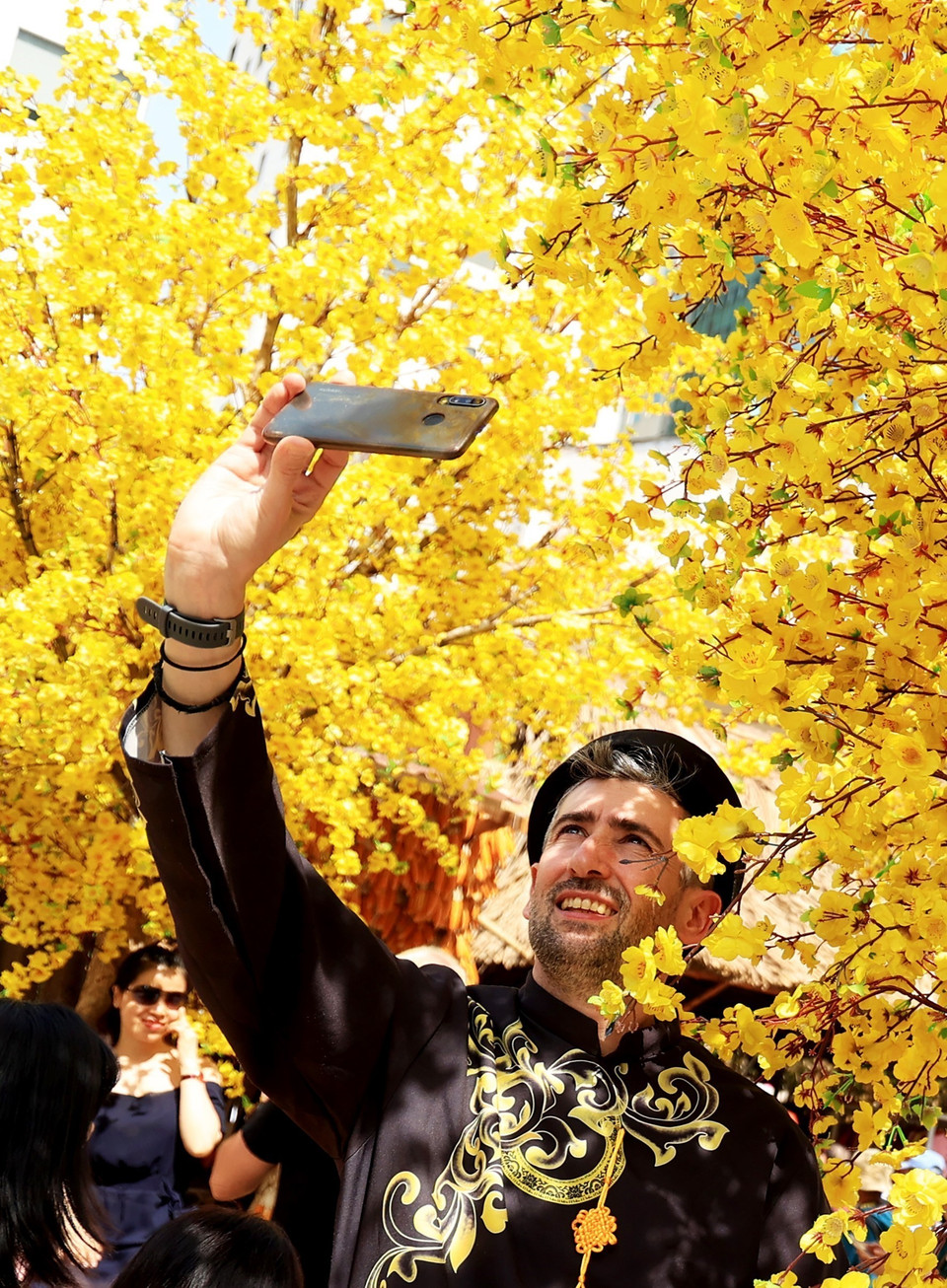 Khách quốc tế trải nghiệm không gian mai vàng đất phương Nam ngày 29 Tết. (Ảnh: Hồng Đạt/TTXVN)