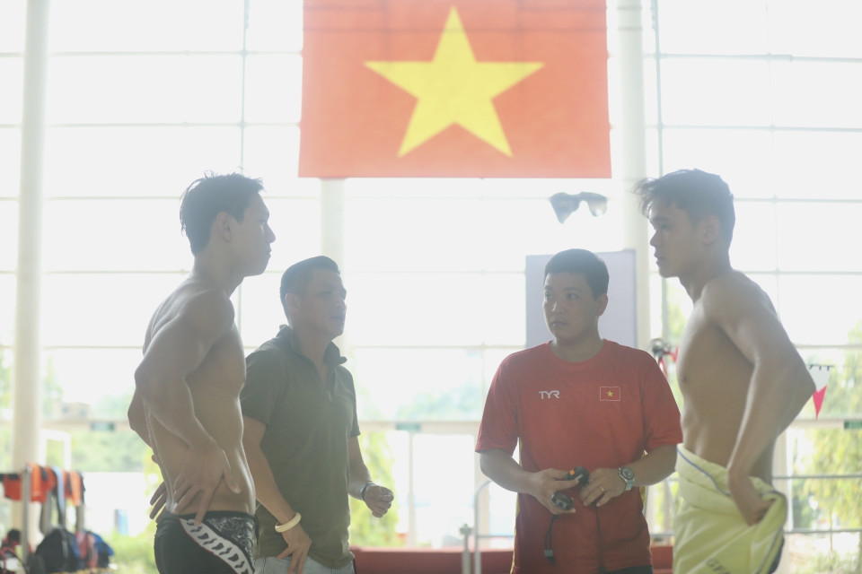 Huấn luyện viên trưởng đội tuyển Bơi Việt Nam Nguyễn Hoàng Vũ (áo đỏ) và các thành viên đội tuyển đang nỗ lực tập luyện, hướng tới các mục tiêu tại SEA Games 31 sắp tới. (Ảnh: Minh Quyết/TTXVN)