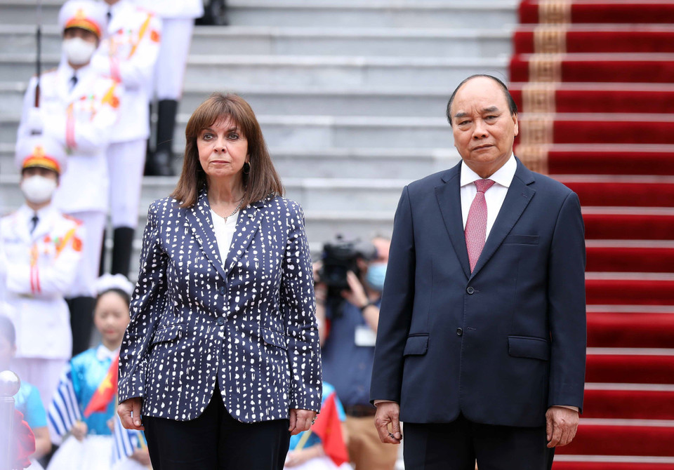 Chủ tịch nước Nguyễn Xuân Phúc và Tổng thống Hy Lạp Katerina Sakellaropoulou đứng trên bục danh dự nghe quân nhạc cử Quốc thiều hai nước. (Ảnh: Thống Nhất/TTXVN)