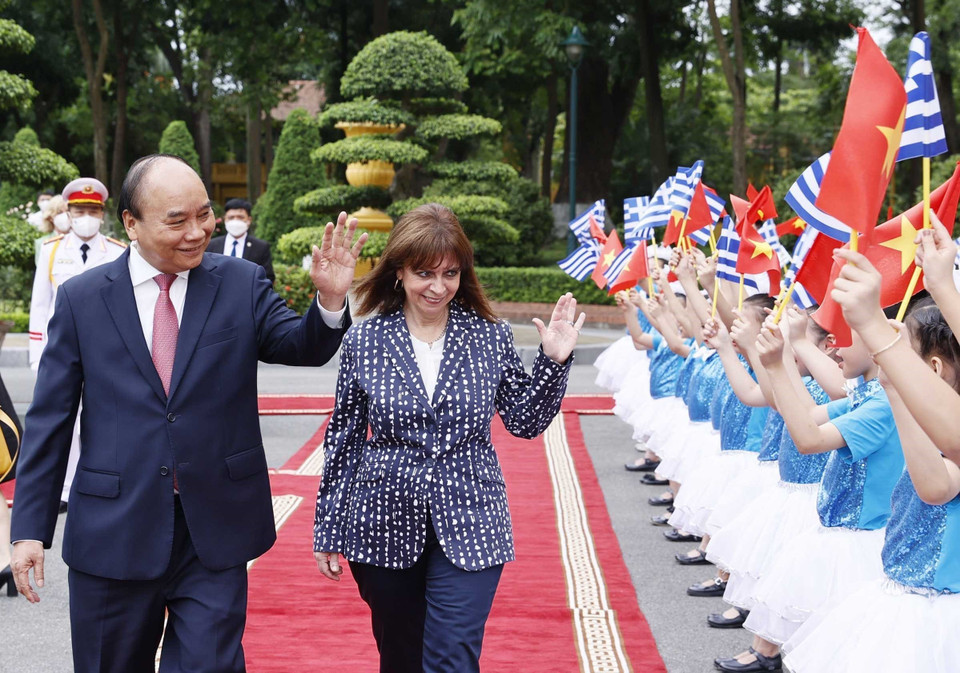 Chủ tịch nước Nguyễn Xuân Phúc và Tổng thống Hy Lạp Katerina Sakellaropoulou với thiếu nhi Hà Nội tại lễ đón. (Ảnh: Thống Nhất/TTXVN)