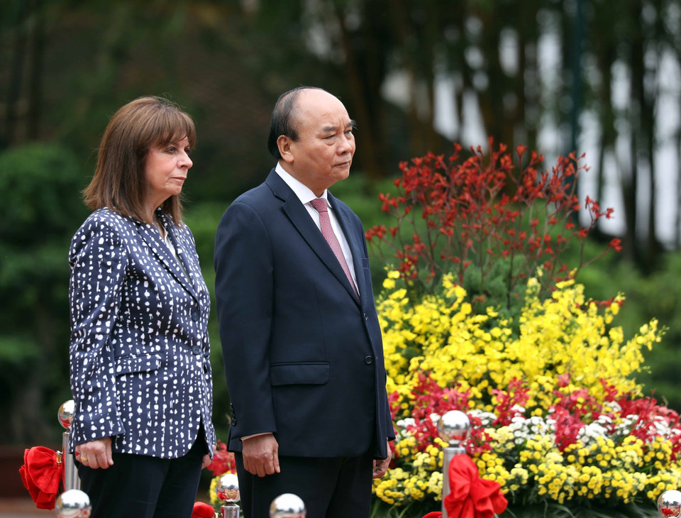 Chủ tịch nước Nguyễn Xuân Phúc và Tổng thống Hy Lạp Katerina Sakellaropoulou nghe quân nhạc cử Quốc thiều hai nước. (Ảnh: Thống Nhất/TTXVN)