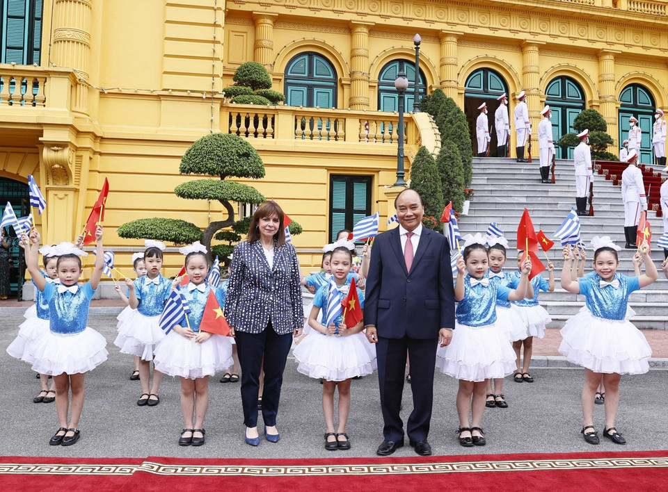 Chủ tịch nước Nguyễn Xuân Phúc và Tổng thống Hy Lạp Katerina Sakellaropoulou với thiếu nhi Hà Nội tại lễ đón. (Ảnh: Thống Nhất/TTXVN)