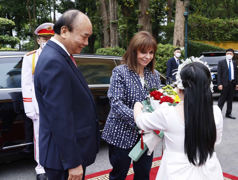 Thiếu nhi Hà Nội tặng hoa Tổng thống Hy Lạp Katerina Sakellaropoulou tại lễ đón. (Ảnh: Thống Nhất/TTXVN)