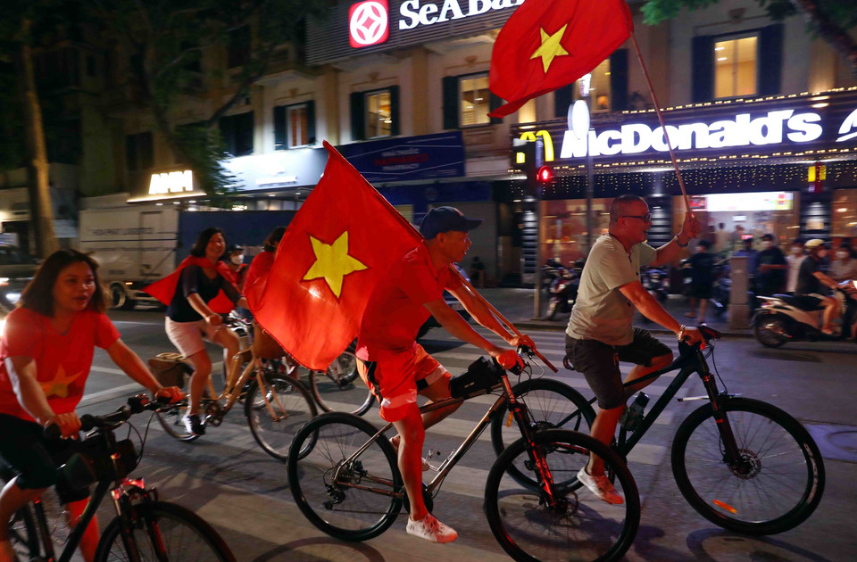 Nhiều người dân Thủ đô mang theo cờ Tổ quốc để ăn mừng chiến thắng của đội tuyển Bóng đá nam U23 Việt Nam. (Ảnh: Phạm Kiên/TTXVN)