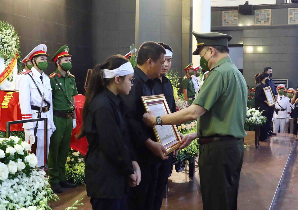 Đại tướng Tô Lâm, Ủy viên Bộ Chính trị, Bộ trưởng Bộ Công an trao Huân chương Chiến công hạng Nhất cho gia đình Thượng úy Đỗ Đức Việt (Cán bộ Đội Cảnh sát phòng cháy chữa cháy và cứu nạn cứu hộ, Công an quận Cầu Giấy). (Ảnh: Phạm Kiên/TTXVN)