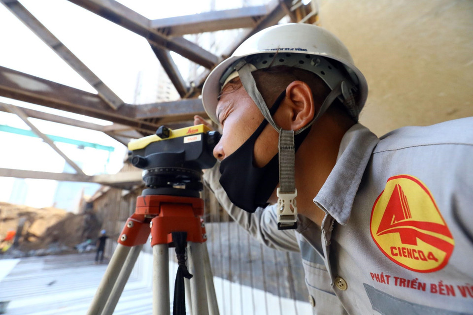 Kỹ sư Nguyễn Đình Trang của Ban điều hành thi công đo cao độ cọc bêtông để hoàn thiện hố móng hầm hở. (Ảnh: Huy Hùng/TTXVN)