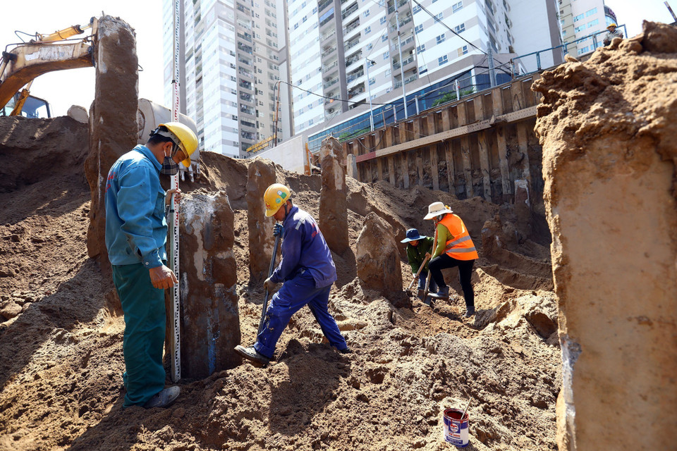 Công nhân đang cắt phần đầu cọc tại khu vực hầm hở. (Ảnh: Huy Hùng/TTXVN)