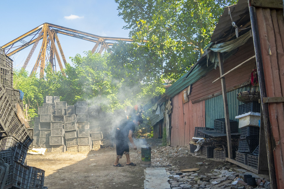 Đặc biệt, ngay gần khu vực ô nhiễm từ bao đời nay đã hình thành những xóm nghèo hoặc khu ở của rất đông lao động tự do, ngoại tỉnh, mưu sinh tại khu vực chợ Long Biên và một số vùng lân cận. (Ảnh: Linh Khánh/TTXVN)