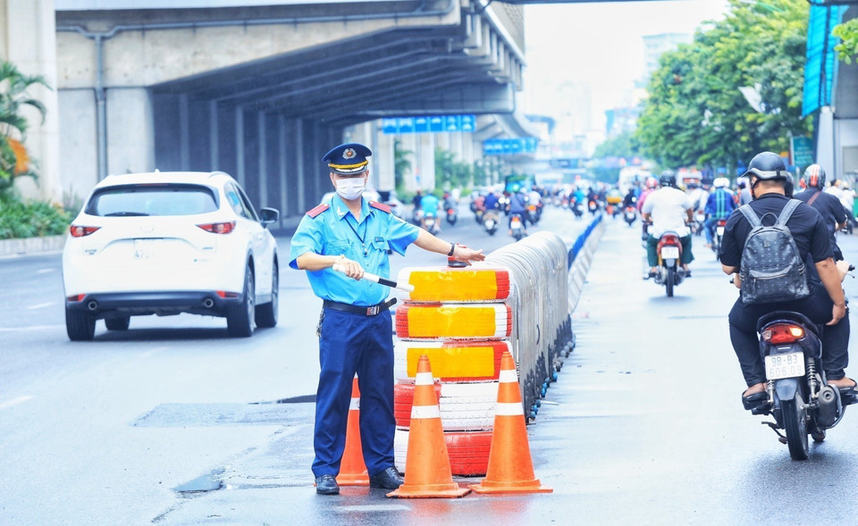 Lực lượng Thanh tra giao thông hướng dẫn phân làn các phương tiện trên đường Nguyễn Trãi. (Ảnh: Tuấn Anh/TTXVN)