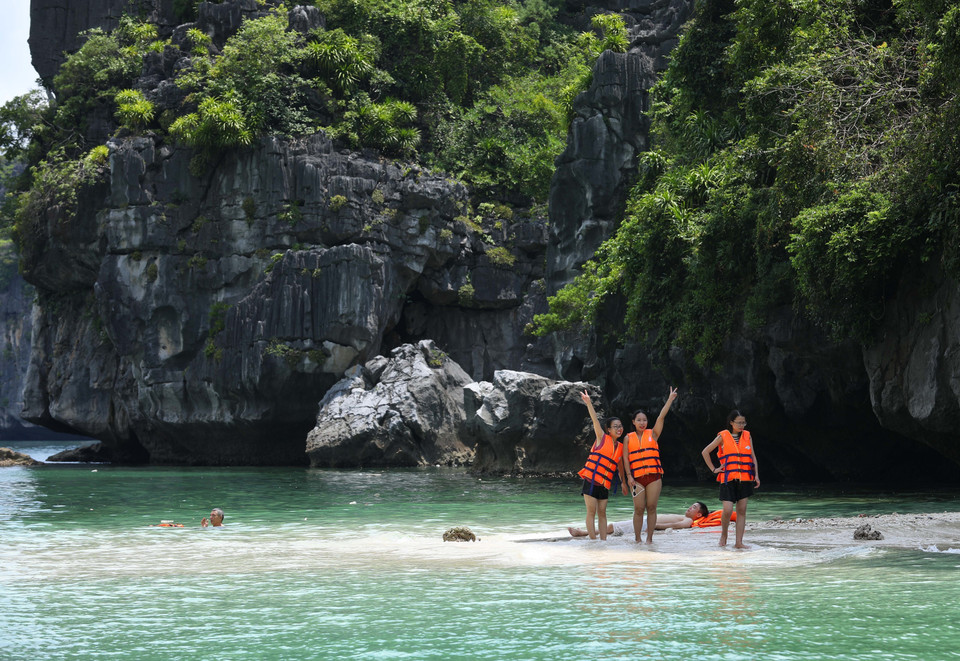 Du khách vui chơi tại bãi biển 3 trái đào. (Ảnh: Hoàng Hiếu/TTXVN)