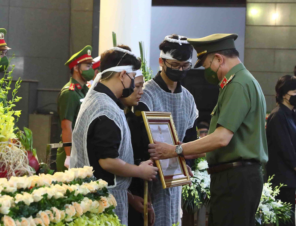 Đại tướng Tô Lâm, Ủy viên Bộ Chính trị, Bộ trưởng Bộ Công an trao Huân chương Chiến công hạng Nhất cho gia đình Thượng tá, Liệt sỹ Đặng Anh Quân (Đội trưởng Đội Cảnh sát phòng cháy chữa cháy và cứu nạn cứu hộ, Công an quận Cầu Giấy). (Ảnh: Phạm Kiên/TTXVN)